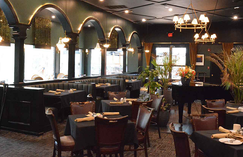 Restaurant interior photography — upscale dining room with arched windows and piano